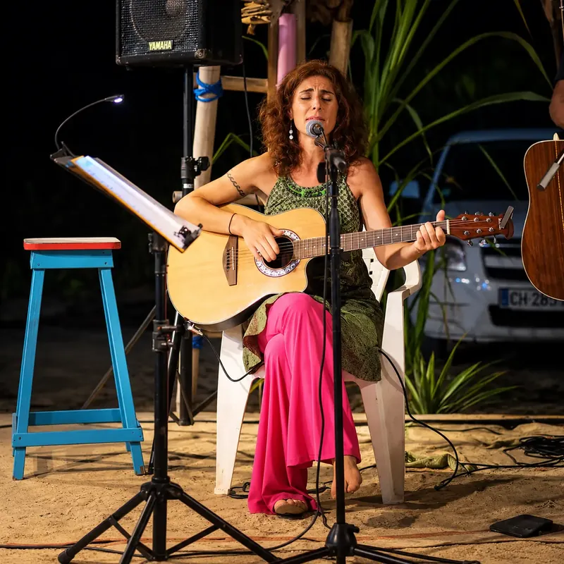 Camille Farge chantant sur scène avec sa guitare